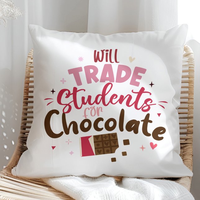 Will Trade Students for Chocolate Funny Teacher Cushion (Will Trade Students for Chocolate Funny Teacher Throw Pillow on a sunny rattan chair.)