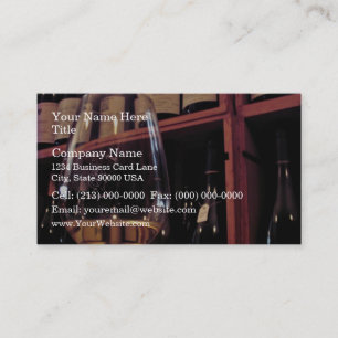 Wine glass with bottles in background business card