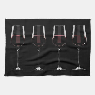 Wine glasses with red wine on black tea towel