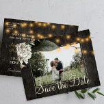 Winter floral and barn wood save the date wedding announcement postcard<br><div class="desc">White cream flowers with seasonal foliage and rustic strings of twinkle lights on dark brown elegant barn wood photo save the date wedding postcard.           Easy to personalise with your names and text!            Suitable for floral winter,  summer or autumn fall / garden backyard rustic country or farmhouse themed weddings.</div>