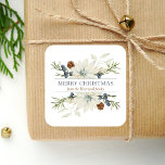 Winter Floral Watercolor Merry Christmas Square Sticker<br><div class="desc">This personalised holiday sticker features a watercolor bouquet of white poinsettias flecked with gold and winter greenery, including brown pine cones and dusty blue berries. In the middle, the words "Merry Christmas" appear in dusty blue serif font on a white background. Personalise the design with your family name below in...</div>