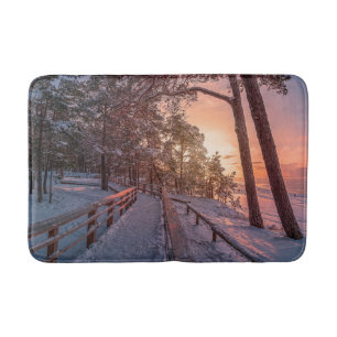 Winter sunset in pine forest near sea bath mat