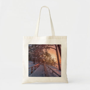 Winter sunset in pine forest near sea tote bag