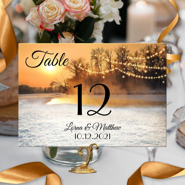 Winter Wonderland String Lights Table Number Card (A festive table number card featuring a winter wonderland scene at sunset with festive string lights)