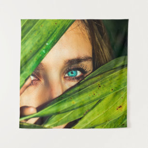 Woman behind green leaves tapestry