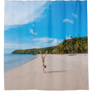 Woman doing acrobatic on seashore near mountain ra shower curtain
