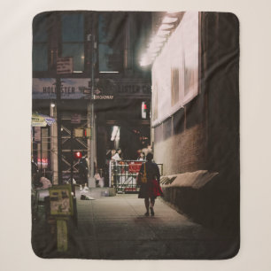 WOMAN IN BLACK AND RED DRESS WALKING BESIDE BROWN SHERPA BLANKET