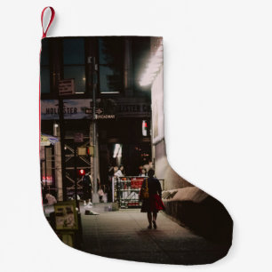 WOMAN IN BLACK AND RED DRESS WALKING BESIDE BROWN SMALL CHRISTMAS STOCKING