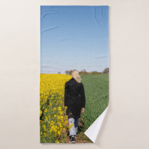 Woman in black coat standing on green grass field bath towel