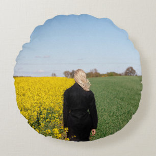 Woman in black coat standing on green grass field  round cushion
