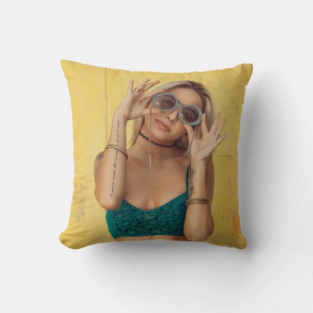 Woman in blue bralette holding sunglasses putting  cushion (Front)