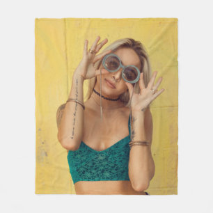 Woman in blue bralette holding sunglasses putting  fleece blanket