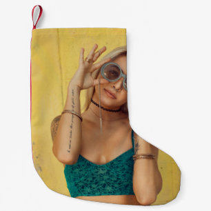 Woman in blue bralette holding sunglasses putting small christmas stocking