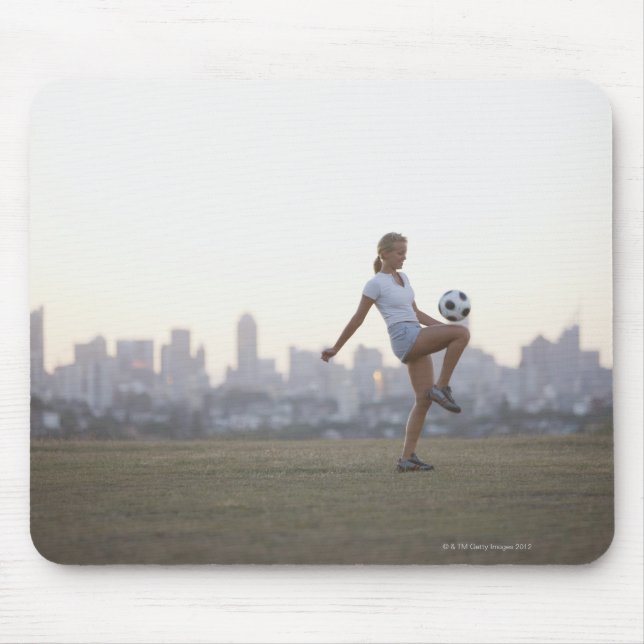 Woman kneeing soccer ball in urban park mouse pad (Front)