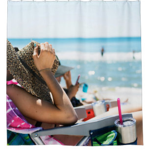 Woman lying on sun lounger covering her face with shower curtain