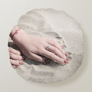 Woman lying on white sand round cushion