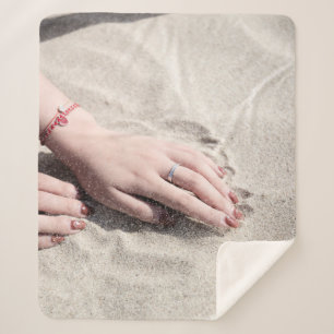 Woman lying on white sand sherpa blanket
