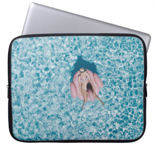 Woman on pink buoy surrounded by body of water in laptop sleeve