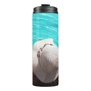 Woman sitting beside swimming pool thermal tumbler