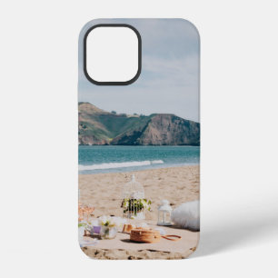 Woman sitting near seashore while looking at Golde iPhone 12 Case