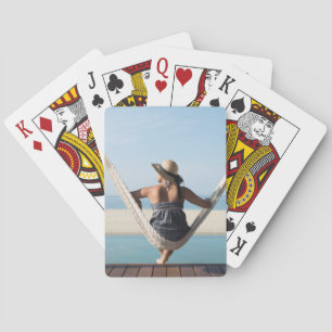 Woman Sitting On A Hammock At A Small Hotel Playing Cards
