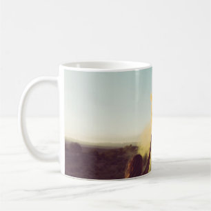 Woman standing on desert holding flare coffee mug