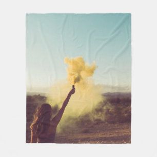 Woman standing on desert holding flare fleece blanket