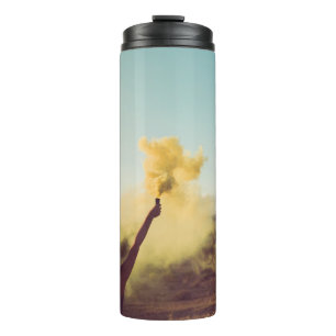 Woman standing on desert holding flare thermal tumbler