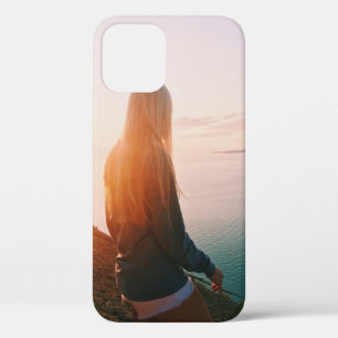 Woman stands near body of water during golden hour iPhone 12 case