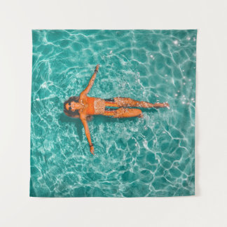Woman swimming alone in body of water tapestry