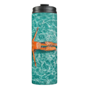 Woman swimming alone in body of water thermal tumbler