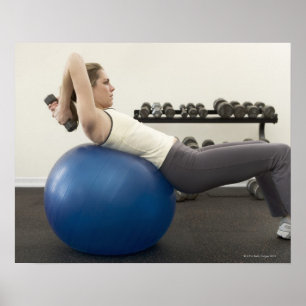 Woman using exercise ball and hand weights poster