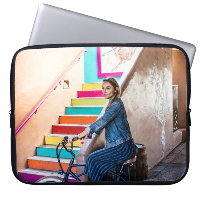 Woman wearing blue denim jacket and shorts riding  laptop sleeve (Front)