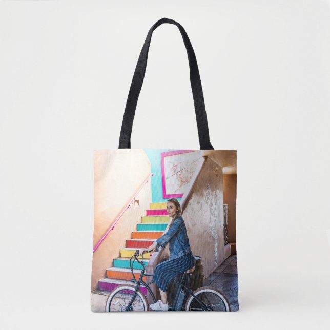 Woman wearing blue denim jacket and shorts riding  tote bag (Front)