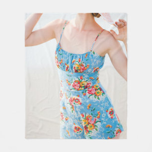 Woman wearing blue floral rompers and brown hat fleece blanket