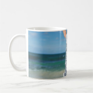 Woman wearing white and black shirt jumping near s coffee mug