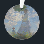 Woman with a Parasol by Claude Monet Ornament<br><div class="desc">Woman with a Parasol - Madame Monet and Her Son by Claude Monet, oil on canvas 1875, is a painting of a woman in a white dress holding an umbrella over her head upon the top of a hill covered in grass and wildflowers, backlit against a brilliant blue sky and...</div>