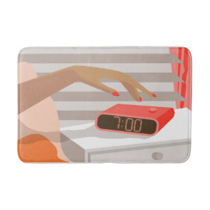 Womans hand pushing on alarm clock snooze button bath mat
