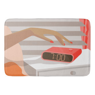 Womans hand pushing on alarm clock snooze button bath mat