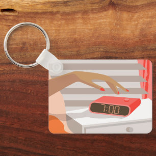 Womans hand pushing on alarm clock snooze button key ring