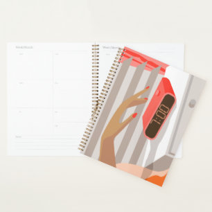 Womans hand pushing on alarm clock snooze button planner