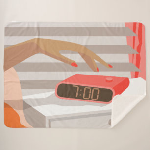 Womans hand pushing on alarm clock snooze button sherpa blanket