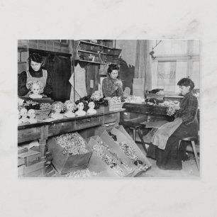 Women making wigs for dolls postcard