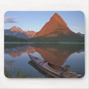 Wooden kayak in Swiftcurrent Lake at sunrise in Mouse Pad