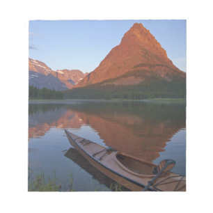 Wooden kayak in Swiftcurrent Lake at sunrise in Notepad