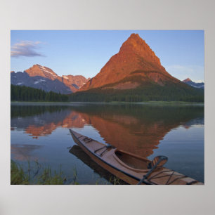 Wooden kayak in Swiftcurrent Lake at sunrise in Poster