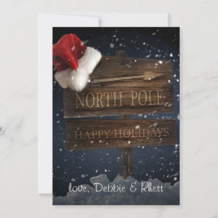 Wooden sign with Santa hat on snowy background Holiday Card