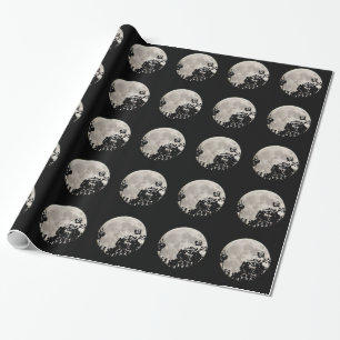 Wrapping paper moon behind black leaves