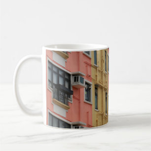 YELLOW AND RED CONCRETE BUILDING UNDER WHITE CLOUD COFFEE MUG