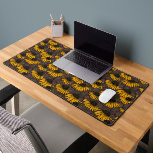 Yellow coneflowers on dark brown desk mat